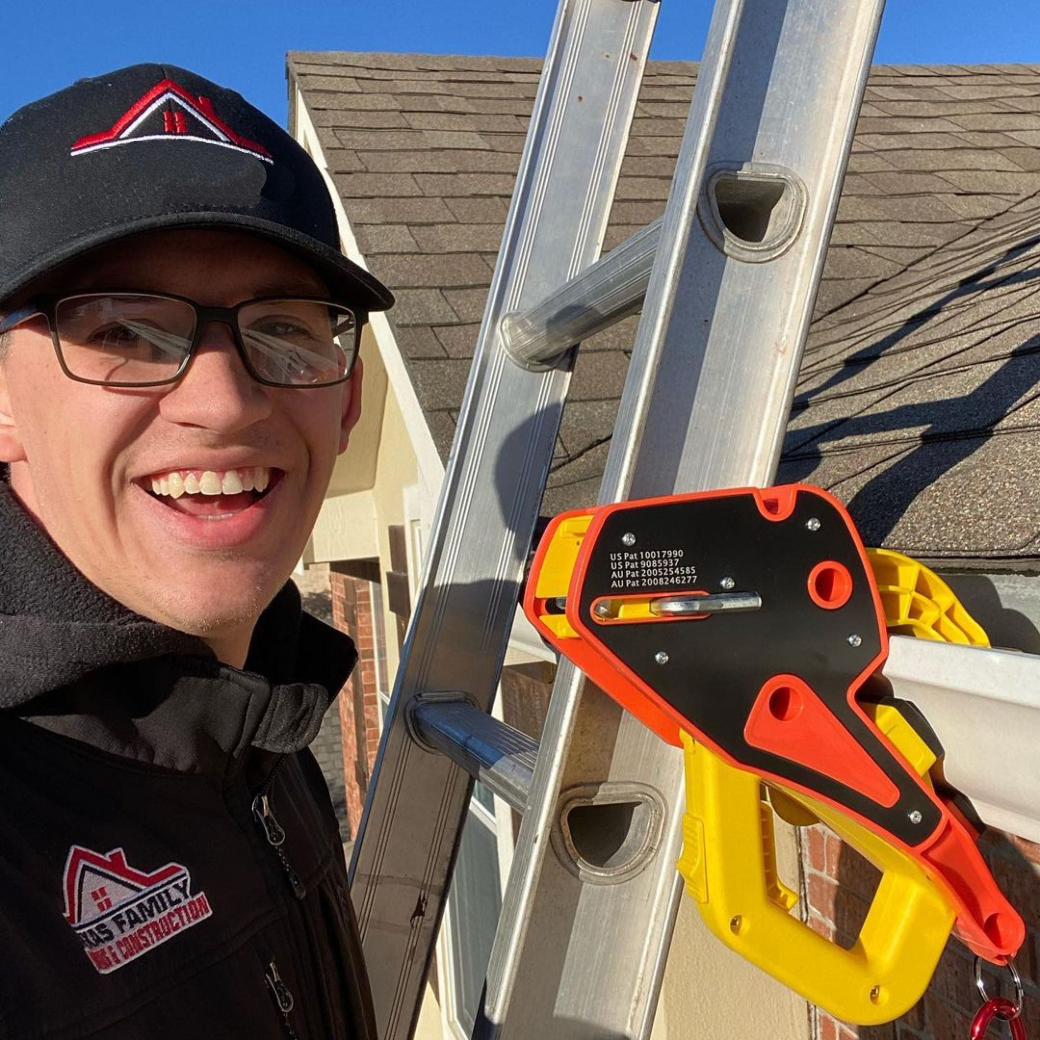 A man with glasses smiles while standing next to a ladder with a Lock Jaw Ladder Grip, with text indicating US and Australian patents.