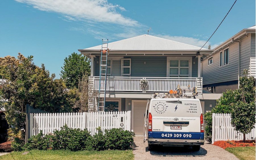 Electrical van in a driveway, ladder up to the gutter of a Queenslander with a Lock Jaw grip at the gutter