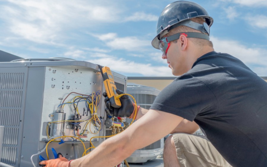HVAC technician working on a rooftop unit