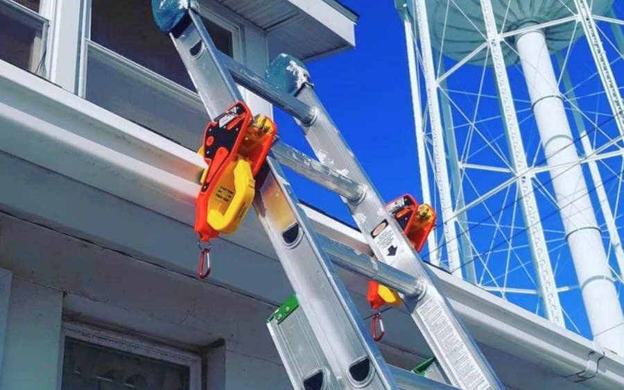 Two extension ladders secured to a roofline with Lock Jaw Ladder Grips