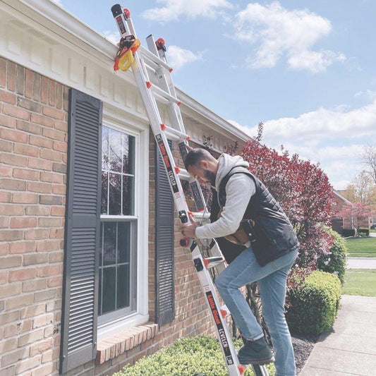 An extension ladder set up and secured at the gutter of a house