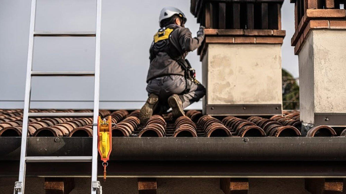Ladder secured at the gutter of a tiled roof