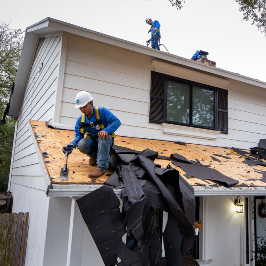 Residential roofer working on a pitched shingle roof