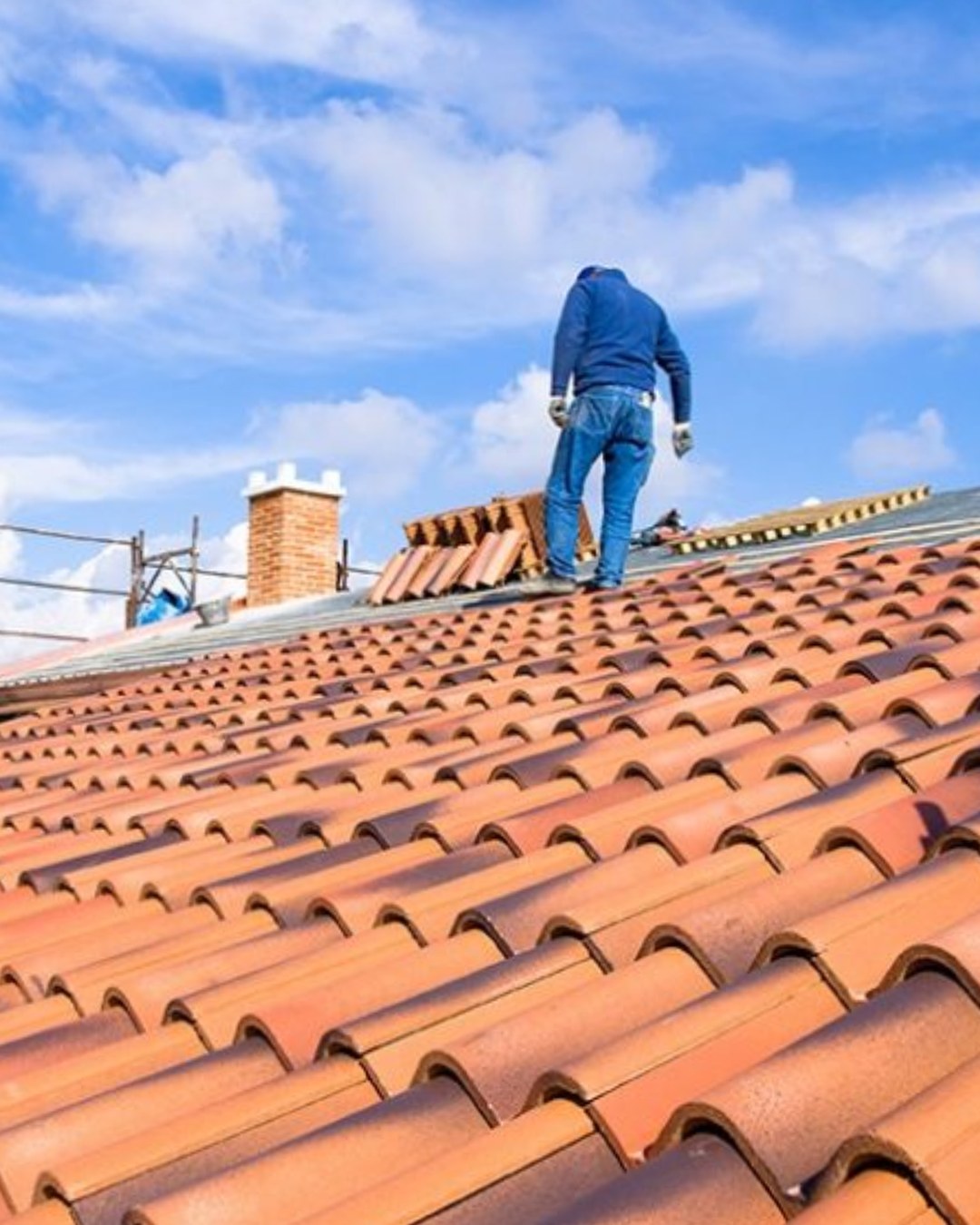 Inspector walking a tiled roof to assess its condition