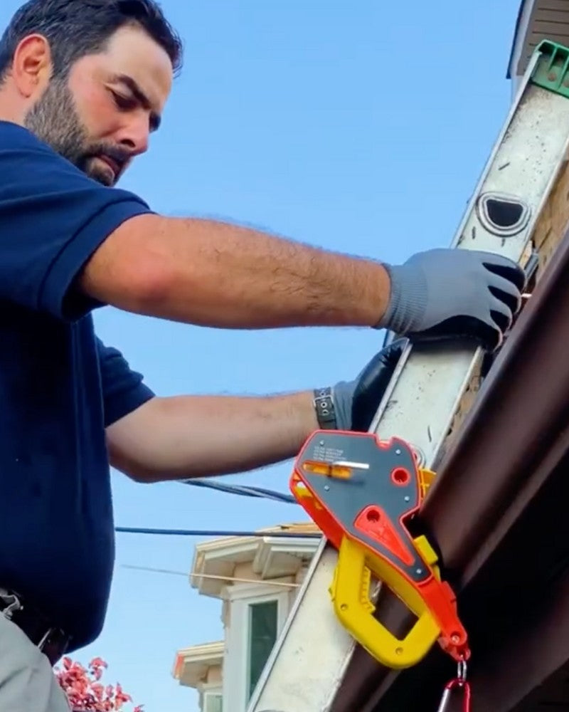 A technician using a Lock Jaw Ladder Grip on an extension ladder